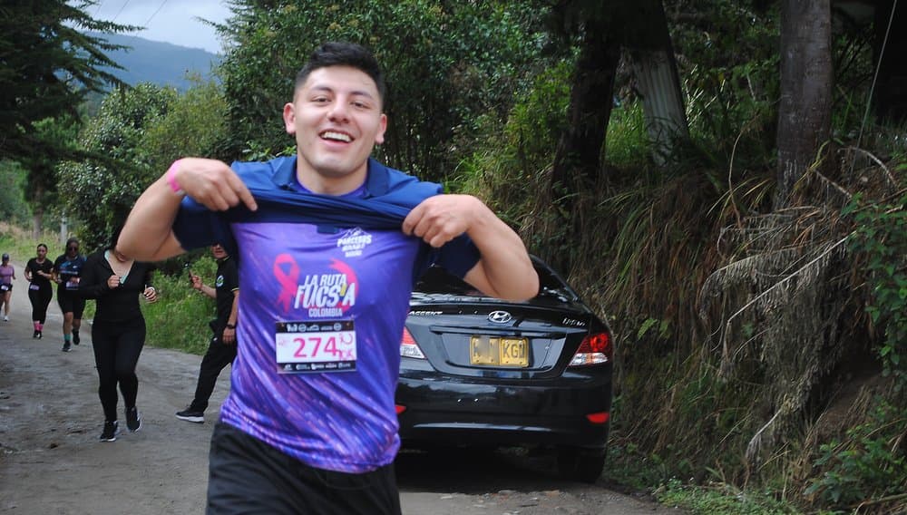 Corredor mostrando su camiseta de Ruta Fucsia